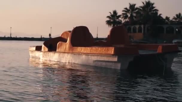 Catamarã ficar na água no mar. Nascer do sol na costa do mar. Praia de areia, lavada pelas ondas do mar na manhã de verão . — Vídeo de Stock