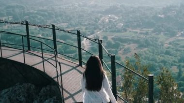 Gözlem güvertesinde koşan beyaz gömlekli bir kız.