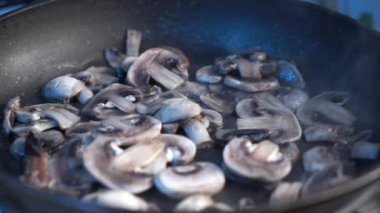 Yemek konsepti. Aşçı bir tavada mantar kızartma.