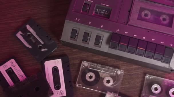 Antiguo reproductor de audio de cassette retro vintage y muchos casetes de audio retro antiguos diferentes en la mesa — Vídeos de Stock