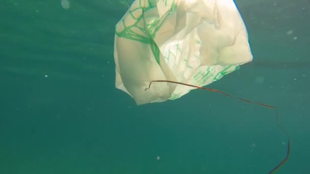 Poluição plástica no oceano problema ambiental. Sacos, palhas e garrafas de plástico, descartados no mar — Vídeo de Stock