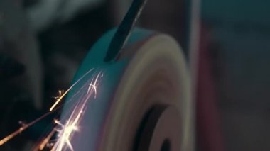 Yavaş çekimde dengesiz bir taşlama makinesi yle eski bir aleti yakın çekimde bileme. Bir retro enstrüman, dönen bir whetstone ve kıvılcım ile geleneksel ekipman bir sahne.