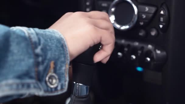 Close-up de motorista feminino mão comutação transmissão automática em carro de luxo antes de dirigir. Preto vista interior do carro, mulher sentada em motoristas assento mudança de engrenagem botão vai dirigir carro — Vídeo de Stock