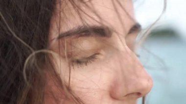 Çekici Genç Gülümseyen Esmer Kız Gözleri Açma ve Kamera Düz Bakarak Portresi. Meltem bir kızın saçlarıyla oynuyor