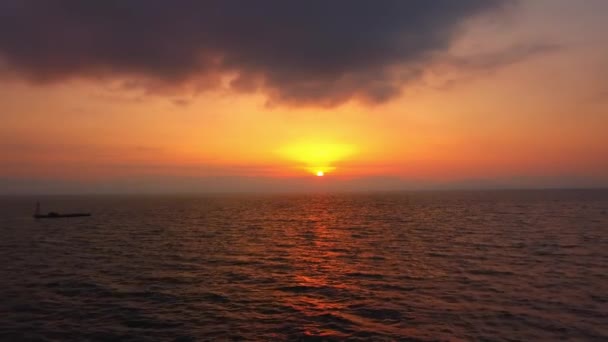 穏やかな海の上に海の太陽線と日の出に反射したぼやけ。太陽は海の真上に昇り、大きな美しい光線が水面に反射します。空中ドローン鳥の目のビュー — ストック動画