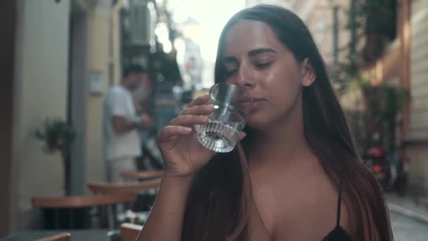 Schöne Frau, die Wasser im Glas trinkt und bei Sonnenuntergang glücklich ist. gesundes Leben, Ernährungskonzept — Stockvideo