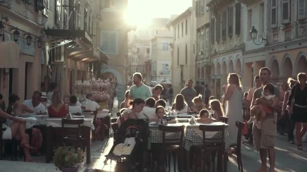 Grecia. Corfú. 2019. Vista de los típicos europeos, acogedores, pequeños restaurantes y cafetería al atardecer — Vídeo de stock