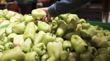 Güzel kız bir süpermarkette yeşil biber seçer