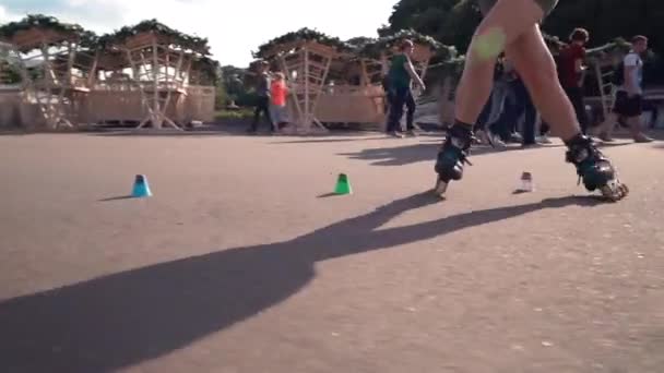 Moscovo. A Rússia. 2019. A jovem vai andar de patins. Atividades ao ar livre no verão. Patinagem. Menina de cabelo marrom em calças andar de patins ao ar livre — Vídeo de Stock