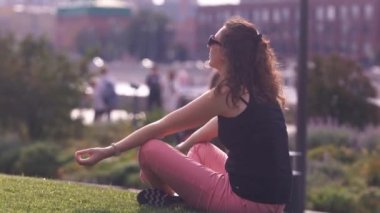 Moskova. Rusya. 2019. Yoga pozisyonunda dışarıda oturan mutlu genç kadın