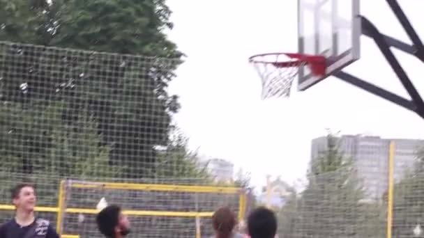 Moscow. Russia. 2019. Teeange sporty streetball team making pick and roll play while playing game on outdoor basketball court. Offensive player setting screen for teammate and moving towards the — Stock Video