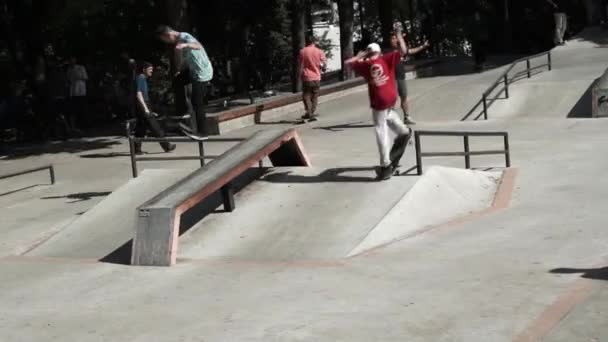 Moscú. Rusia. 2019.Un niño practica skate en el skate park y realiza trucos profesionales. Concepto de: patinador, potencia, libertad, urbano y sueño. skate park con multitud de gente jugando — Vídeos de Stock