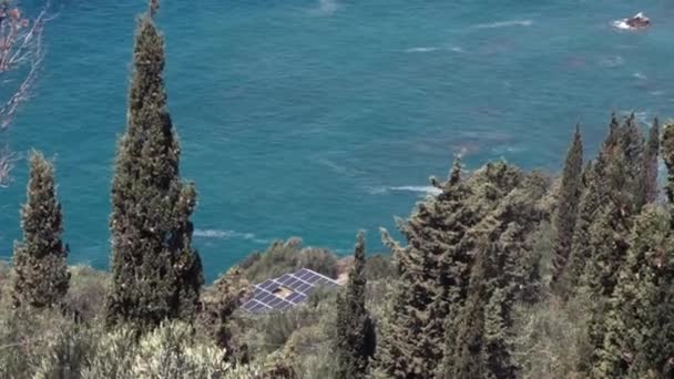 Вид с воздуха на солнечные батареи среди кокосовых пальм и тропический остров — стоковое видео