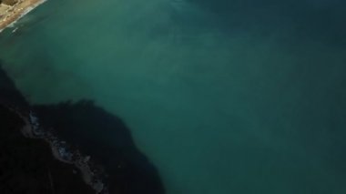 Yunanistan 'ın Korfu Adası' ndaki popüler plajın havadan görünüşü. Gerçekçi olmayan bir şekilde canlı suyla çevrili çift aynalı körfez sahili.
