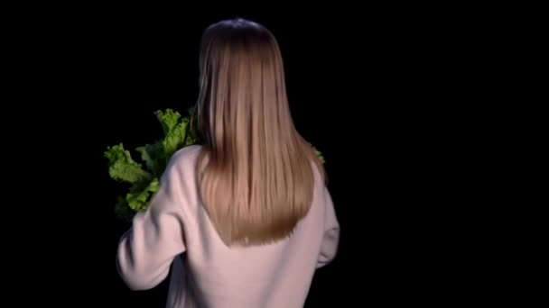 Elinde temiz sebzeler tutan güzel bir genç kız, siyah arka planda. Kavram: sağlıklı gıda, biyoloji, biyolojik ürünler, biyolojik ekoloji, sebze yetiştirme, doğal saf ve taze ürün — Stok video