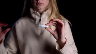 Regl konsepti, kızlarda yumurtlama. Siyah arka planda tampon tutan bir kız..