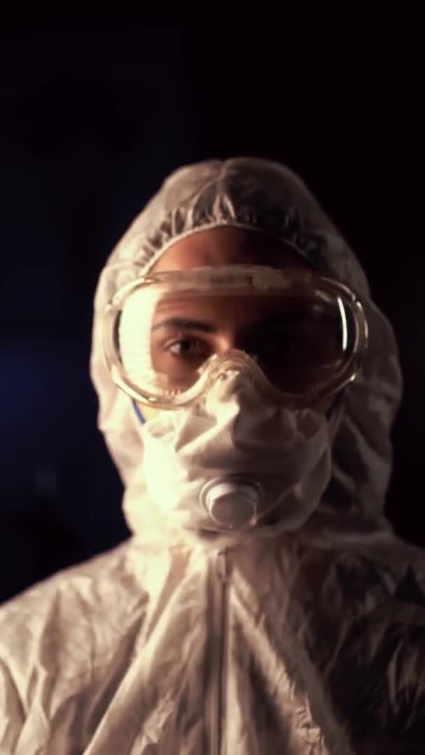 Porträtt av epidemiolog som skyddar patienter från coronavirus COVID-19 i mask. Doktor virolog arbetar i kostym och glasögon i laboratorium. Vertikal video — Stockvideo