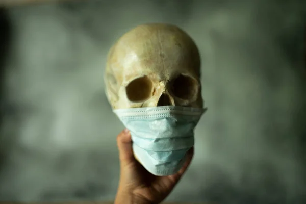 Caveira COVID-19 usando máscara médica facial. Conceito de morte por coronavírus. — Fotografia de Stock
