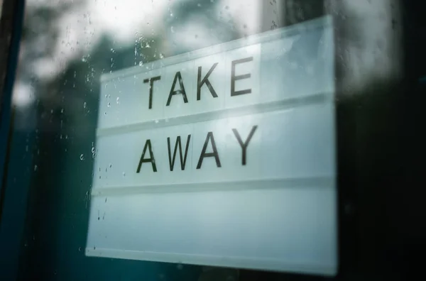 Lightbox s nápisem Take Away za skleněnými dveřmi kavárny. — Stock fotografie