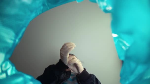 Koronavirüs üzerindeki karantina zaferinin sonu. Çöp kutusundan bir adam tıbbi maskesini çıkarıp atıyor. Virüslere karşı tek kullanımlık kişisel koruyucu ekipmana sahip çöp kutusu — Stok video