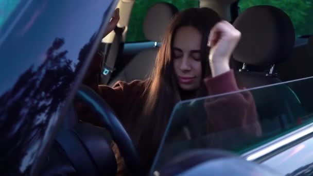 Dziewczyna prowadzi samochód, jest w dobrym nastroju, śpiewa i tańczy. — Wideo stockowe