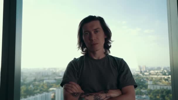 Porträtt av snygg kille med tatuering och trendig frisyr stående i fönsterstaden bakgrund tittar på kameran. Ungdom och modern stadslivsstil. — Stockvideo