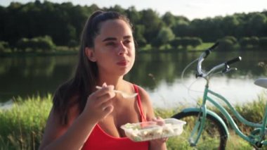 Fitness ve sağlıklı yiyecekler. Kadın dinleniyor ve bisikletten sonra sağlıklı yiyecekler yiyor. Sağlıklı yaşam tarzını kabul et