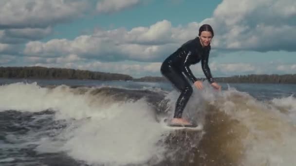 Surfeando. Chica despierta surfeando en el río y cae. Haz un truco de 360. Agua deporte extremo. Movimiento lento — Vídeos de Stock
