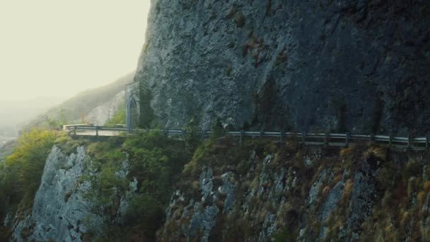 Pequeño scooter que conduce en el camino serpentino estrecho vacío de la montaña en la tarde soleada del verano — Vídeo de stock