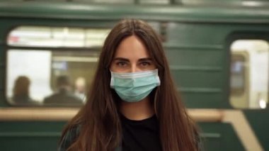 Maskeli yolcular metro istasyonu koronavirüsü dursun. Kadın kamera covid-19 'a bakıyor. Maskeli kız metro trenini bekliyor. Maskeli insanları Corona Virüsü 19 'da görün..