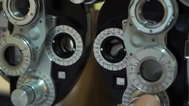 Caucasian female optometrist examining young patient on chiropter in ophthalmology clinic. Close up — Stock Video