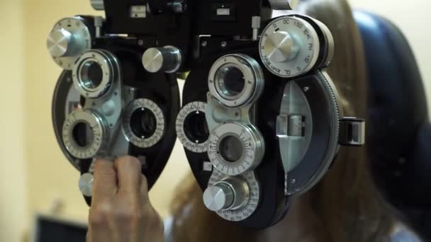 Caucasian female optometrist examining young patient on chiropter in ophthalmology clinic — Stock Video