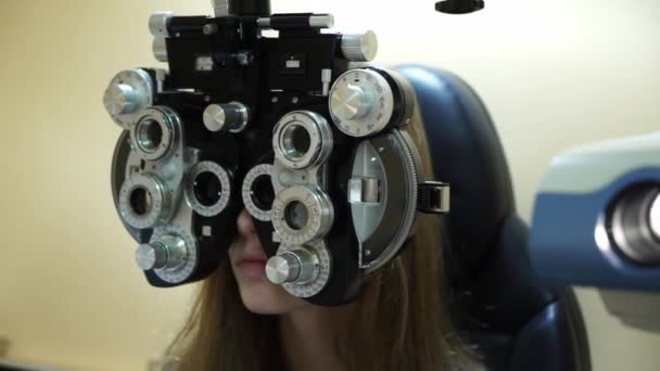 Caucasian female optometrist examining young patient on chiropter in ophthalmology clinic — Stock Video