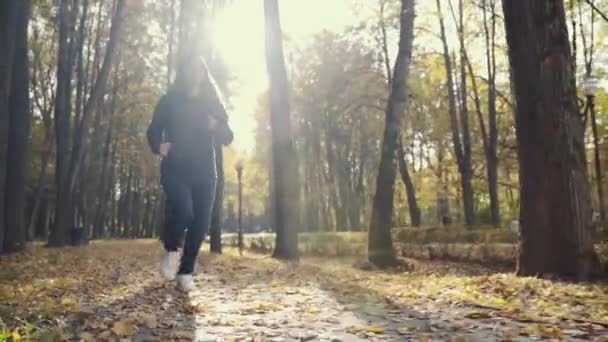 Жінка біжить в парку займається спортом. бігун спортсменка, що біжить на природі стежки. жінка на ранковому бігу зелений парк здорові люди керують парком активна концепція . — стокове відео