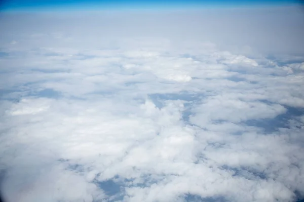 Wolken en lucht gezien door het raam van een vliegtuig — Stockfoto