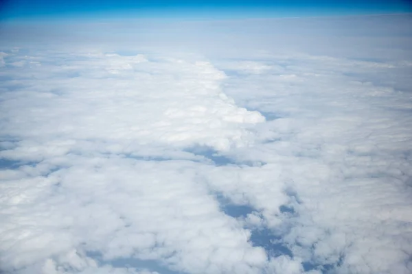 Nuvens e céu como visto através da janela de uma aeronave — Fotografia de Stock