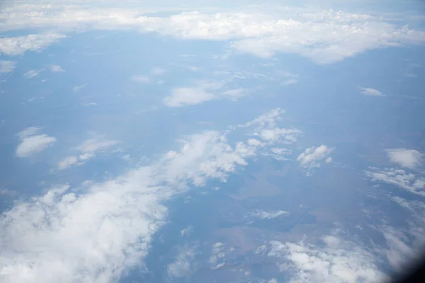 Nuvens e céu como visto através da janela de uma aeronave — Fotografia de Stock