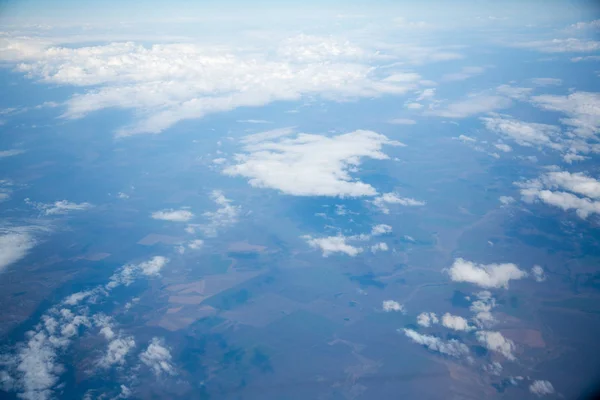 Nuvens e céu como visto através da janela de uma aeronave — Fotografia de Stock