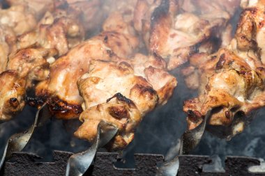 Metal şişte pişen ızgara kebap. Barbeküde pişmiş et. Barbekü taze et dilimleri. Geleneksel doğu yemeği, şiş kebap. Kömür ve alevler üzerine ızgara, piknik, sokak yemekleri