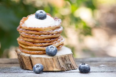 Bal ve ahşap arka plan üzerinde yaban mersini ile lezzetli gözleme yığını. kopya alanı ile