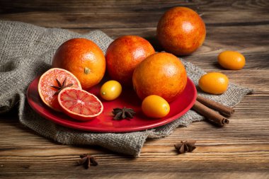 Lezzetli kırmızı portakal ve ahşap arka plan tabaklarda Kamkat kapatın.