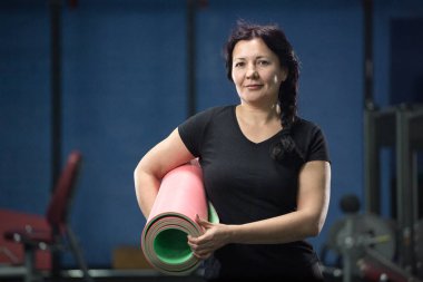 Spor salonunda pembe yoga mat tutan kıdemli kadın. Close. Kopyalama alanı.
