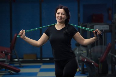 Yaşlı kadın, omuzlarında bir ip olan spor salonunda duruyor. Close. Kopyalama alanı.