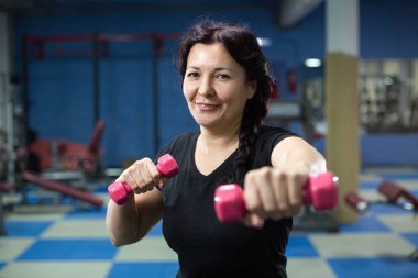Spor salonunda yaşlı kadın, dumbbells ile çalışıyor. Close. Kopyalama alanı.