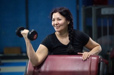 Spor salonunda yaşlı kadın, dumbbells ile çalışıyor. Close. Kopyalama alanı.