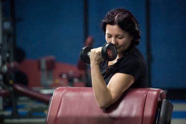 Spor salonunda yaşlı kadın, dumbbells ile çalışıyor. Close. Kopyalama alanı.