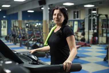 Spor salonunda kıdemli kadın bir koşu bandı üzerinde yürüyor. Close. Kopyalama alanı.