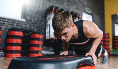 Step şınav aerobik fitness Club üzerinde yapan atlet erkek yatay bir kadeh. Yakışıklı erkek göğsüne Step modern spor salonunda egzersiz olduğunu. Spor, yaşam tarzı ve insanlar kavramı.