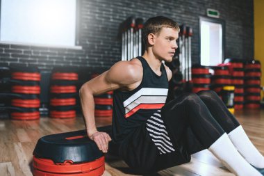 Step Aerobik fitness Club üzerinde Triceps exercices yapan genç sportif erkek. Yakışıklı erkek onun triceps üzerinde Step modern spor salonunda egzersiz olduğunu. Spor, yaşam tarzı ve insanlar kavramı.