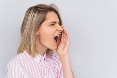 Yan görünüm portre portre duygusal deli şık genç kadın bağırır yüksek sesle ve öfkeyle, stresli, beyaz arka plan üzerinde izole olumsuz duygular ifade eder. Duygu ve insanlar kavramı